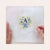 A woman is completing her Sweet Coast Monogram needlepoint project with the letter A.