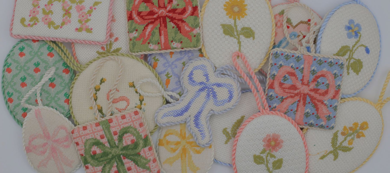 Several needlepoint ornaments are clustered together.